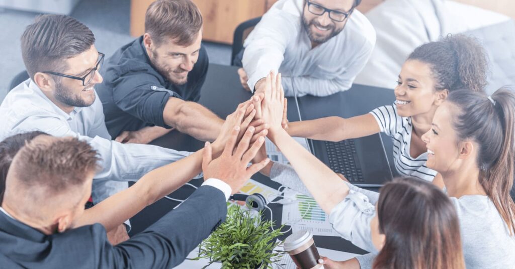 Pessoas dando as mãos para conectar os departamentos com Software de Workflow para Cadeia de Suprimentos